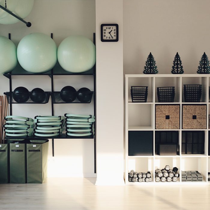 Sala fitness z wyposażeniem, w tym piłkami, matami i ciężarkami.